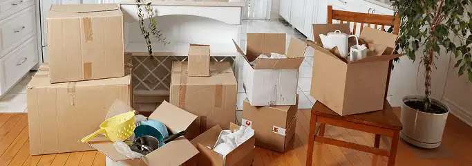 Packed moving boxes and household items in a kitchen before move-out or move-in cleaning, El Paso, TX.