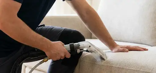 Professional upholstery cleaner deep-cleaning a fabric sofa with a handheld extraction tool, El Paso, TX.